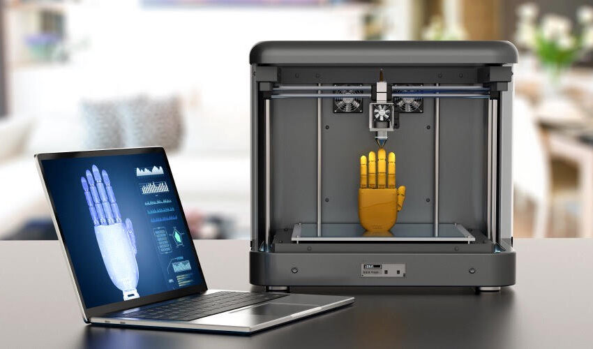 Blueprint of prosthetic hand on laptop and 3D printer printing 3D prosthetic hand
